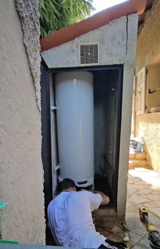 une personne regardant un grand chauffe eau